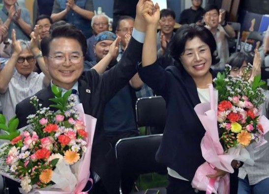 육동한 당선인(왼쪽)이 아내와 함께 손을 들어 인사하고 있다