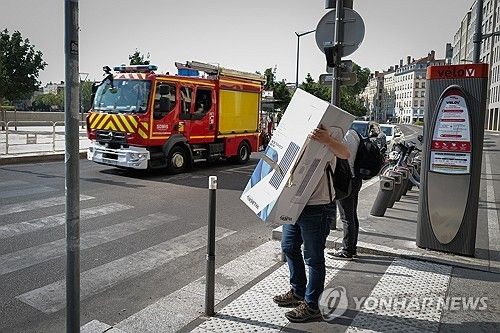 지난 24일 이동식 에어컨 사 들고 가는 프랑스 시민