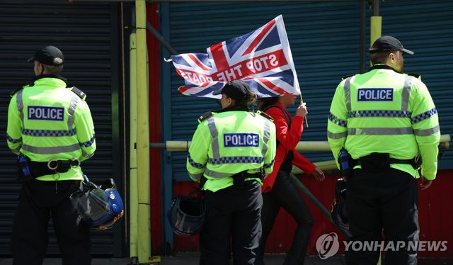 6월 13일 리버풀에서 '보트를 막아라' 깃발을 들고 경찰 앞을 지나는 반이민 시위자