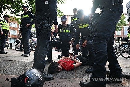 30일 네덜란드 헤이그 경찰이 한 모로코 팬을 제압해 수갑을 채운 모습 [AP=연합뉴스. 재판매 및 DB 금지] 