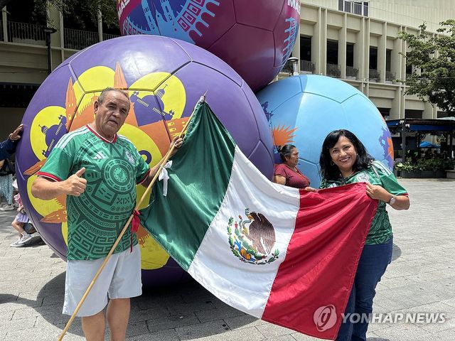 멕시코 국기 들고 기념 사진 찍는 헤수스와 로타 벨라스케스 부부(좌측부터) 