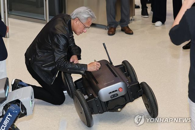 로봇에 사인하는 젠슨 황 CEO