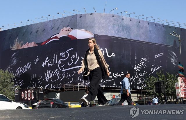 반미 대형 선전물 앞을 지나다니는 이란 시민들