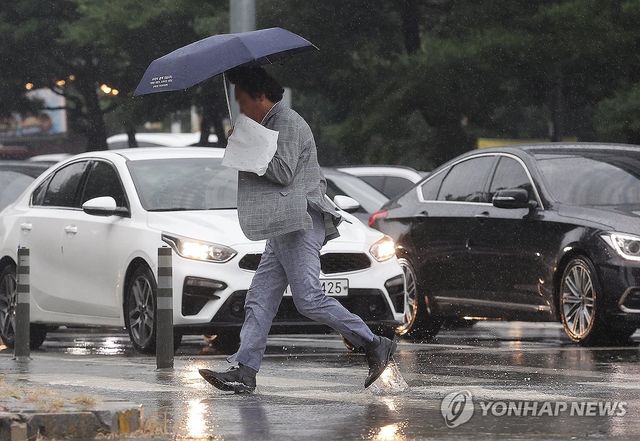 한 시민이 물이 차오른 횡단보도를 건너고 있다. [연합뉴스 자료사진]