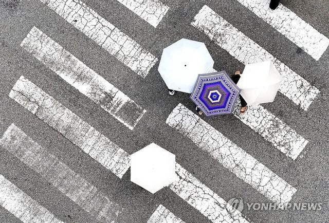 양산 쓰고 이동하는 시민들