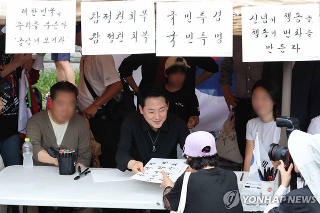 집회 참가자들에게 붓글씨 써주는 장동혁 대표