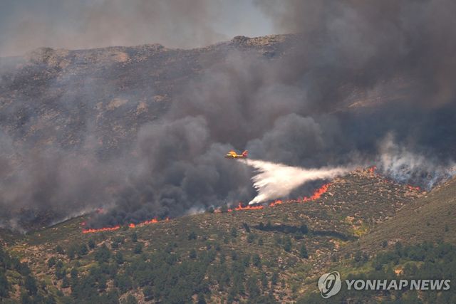 소방 항공기가 아빌라 산불 현장에 물을 뿌리고 있다