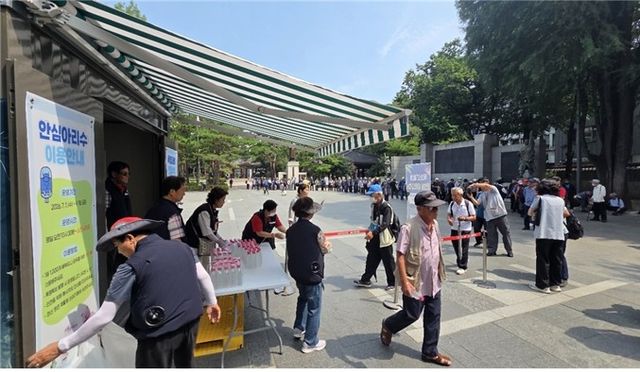 탑골공원에 설치된 '아리수 나눔 냉장고'에서 병물 아리수 나눠주는 모습