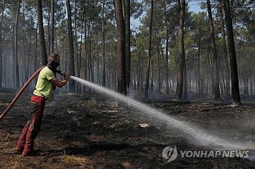 프랑스 남서부 산불 현장에서 지역 주민이 호스로 잔불을 끄고 있다.
