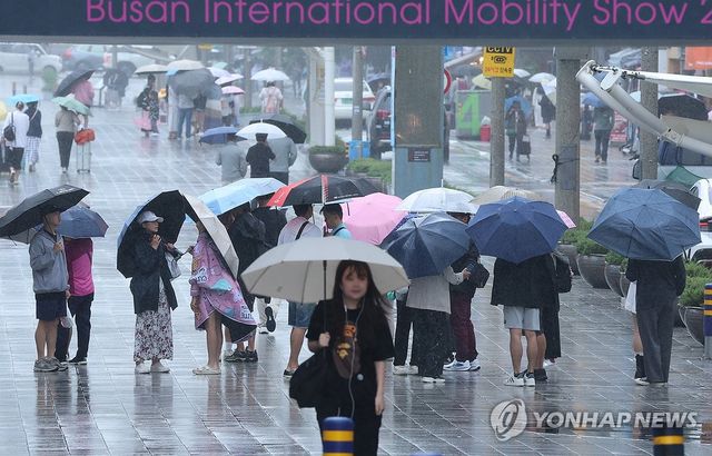 부산 해운대구 구남로에서 우산을 쓴 관광객들이 발걸음을 옮기고 있다. [연합뉴스 자료사진]