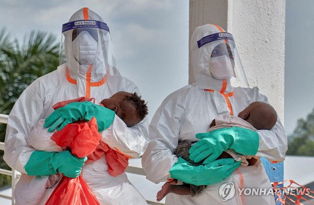 지난달 9일 콩고민주공화국 이투리주 부니아의 한 병원에서 개인보호장구를 갖춘 의료진이 에볼라 검사를 한 아이를 안고 있다.[로이터=연합뉴스 자료사진. 재판매 및 DB 금지]