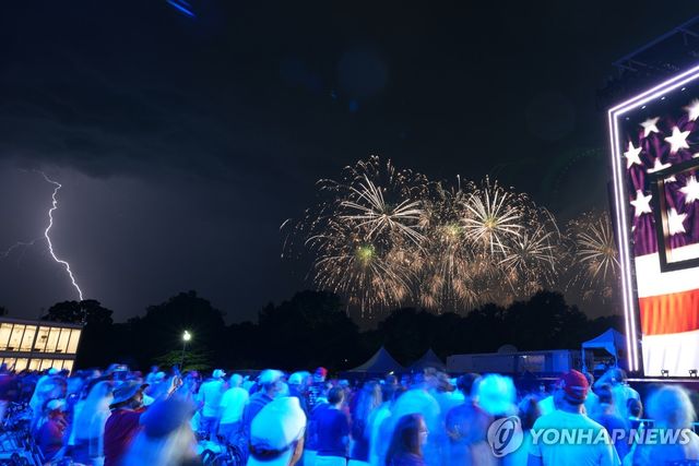 5일(현지시간) 자정께 미국 워싱턴DC에서 열린 미 건국 250주년 기념 불꽃놀이가 열리는 동안 한쪽에 서 번개가 치고 있다. 
