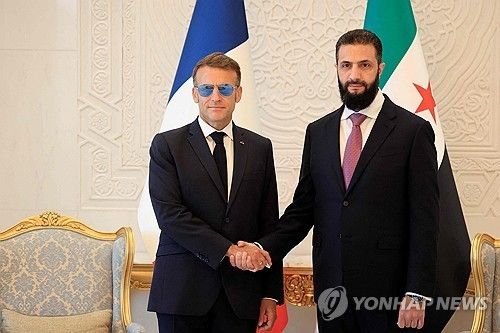 아흐메드 알샤라 시리아 대통령(오른쪽)과 악수하는 마크롱 대통령(왼쪽) 