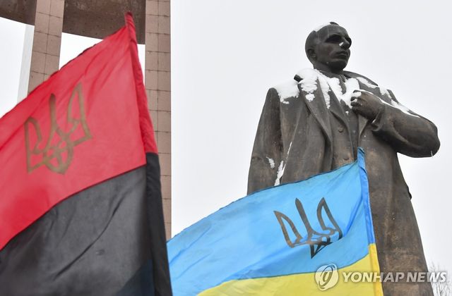 우크라이나 르비우의 스테판 반데라 동상과 UPA 깃발(왼쪽)