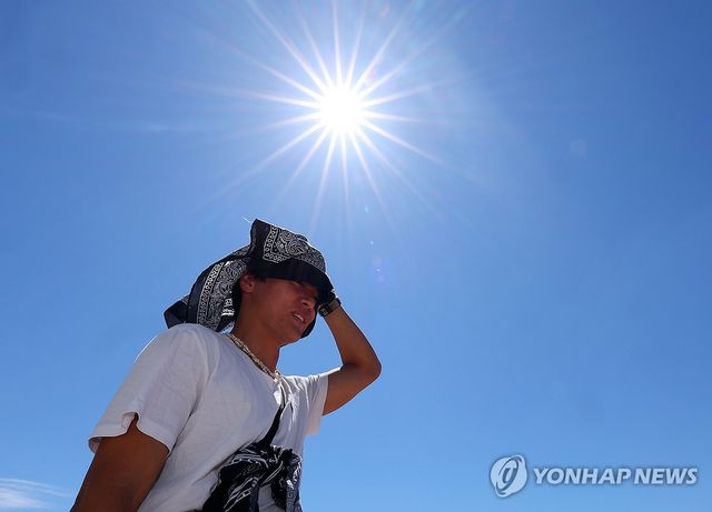 부산 수영구 광안리해수욕장에서 한 피서객이 손수건으로 뜨거운 햇빛을 가리고 있다. [연합뉴스 자료사진]