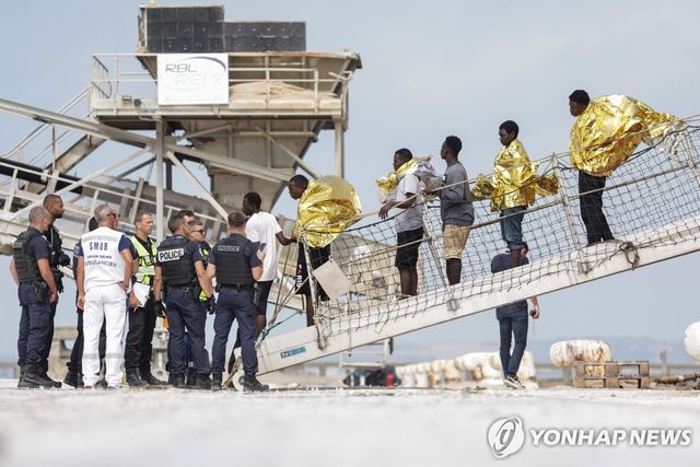 해협 건너다가 화재가 난 보트에서 이주민들이 구조돼 프랑스에서 하선하고 있다