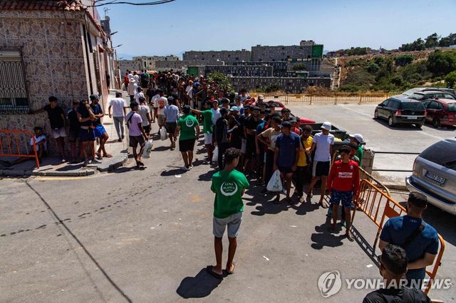 세우타서 식료품 배급 줄 선 이주민들 