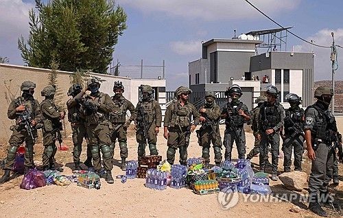 요르단강 서안 쿠스라 마을에서 이스라엘 정착민들에게 포위된 팔레스타인 가옥 입구 앞에 이스라엘 군인들이 서 있다. 이스라엘 좌파 활동가들과 연대 단체 자원봉사자들은 고립된 주민들을 위해 구호품을 내려놓았지만, 군인들이 반입을 막았다. [AFP 연합뉴스. 재판매 및 DB 금지]