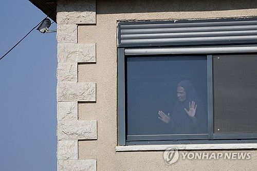 유대인 정착촌 운동가들이 봉쇄한 요르단강 서안 쿠스라 마을에서 한 팔레스타인 여성이 창밖을 내다보고 있다. [로이터 연합뉴스. 재판매 및 DB 금지]