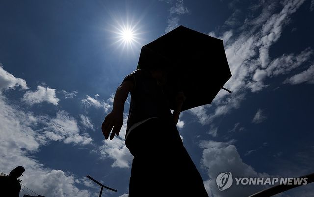 양산을 쓰고 이동하는 시민. [연합뉴스 자료사진]