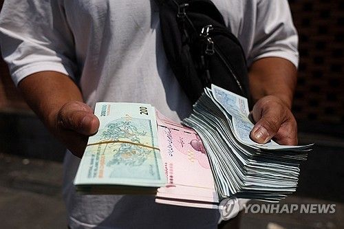 2026년 8월 17일 이란 테헤란 그랜드 바자르에서 한 환전상이 이란 리알화를 들고 있다. [로이터 연합뉴스. 재판매 및 DB 금지]