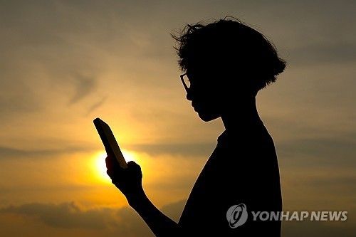 핸드폰을 보는 소년 