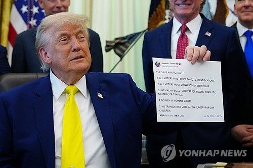 자신의 트루스소셜 게시물 사진을 들어보이고 있는 트럼프 대통령 