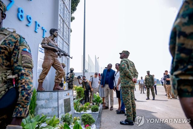 1일(현지시간) 우간다 엔테베 국제공항 옛 터미널 앞에서 무후지 카이네루가바 우간다 군 총사령관이 요나탄 네타냐후 중령의 동상을 보고 있다. [Uganda People's Defence Forces Press Service/AP=연합뉴스. 재판매 및 DB 금지]