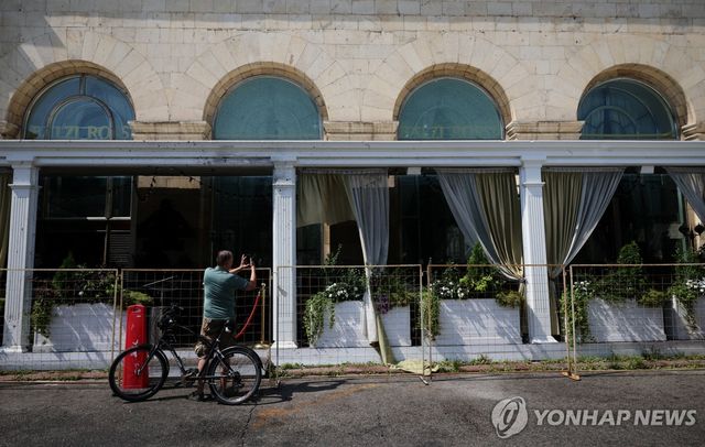 2일(현지시간) 폭탄 공격 장소인 러시아 모스크바의 발치 로시 레스토랑 앞에서 한 시민이 사진을 찍고 있다.