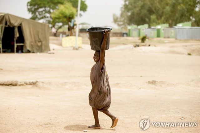 기후변화로 차드호가 축소되고 가뭄이 심화하면서 한 어린이가 양동이를 들고 지나가고 있다. [AP 연합뉴스 자료사진. 재판매 및 DB 금지]
