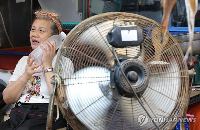 얼린 페트병 들고 폭염 이겨내는 상인