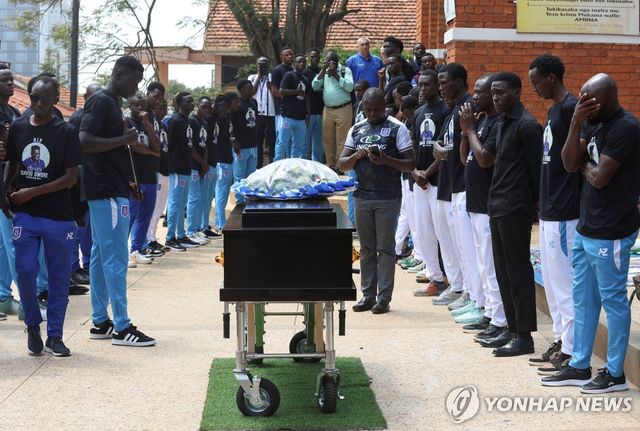 6일 우간다 수도 캄팔라 성베드로 성당에서 전날 숨진 데이비드 오워리 선수의 추모 미사가 시작하기 앞서 축구 선수들이 그의 관 옆에 서 있다. [로이터=연합뉴스. 재판매 및 DB 금지]