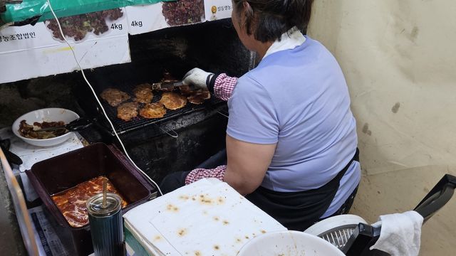 불 앞에서 고기 굽는 가게 직원