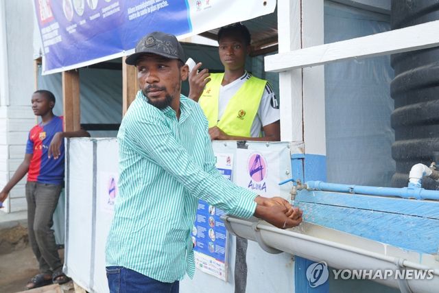 콩고민주공화국 이투리주의 에볼라 치료소에서 한 보건 종사자가 손을 씻고 있다.[AP=연합뉴스. 재판매 및 DB 금지]