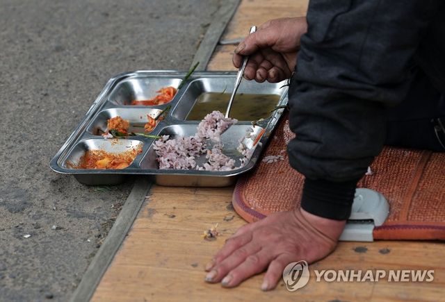 홀로 식사하는 쪽방촌 주민