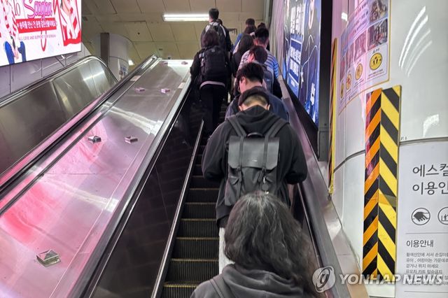 한 줄 서기로 에스컬레이터를 이용하는 사람들
