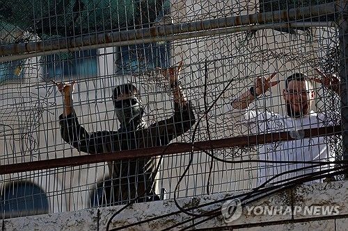 2026년 9월 5일 이스라엘이 점령 중인 요르단강 서안 헤브론에서 열린 이스라엘 정착민들의 주간 투어 도중, 한 이스라엘 군인과 정착민이 손짓을 하고 있다. [로이터 연합뉴스. 재판매 및 DB 금지]