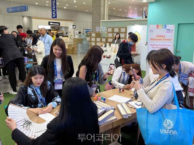일산 킨텍스에서 진행중인 유사나헬스사이언스의 '2023 아시아 태평양 컨벤션' 기업회의 내 한국관광 홍보부스에서 참가자가 합죽선에 한글이름 도장찍기 체험을 하는 모습