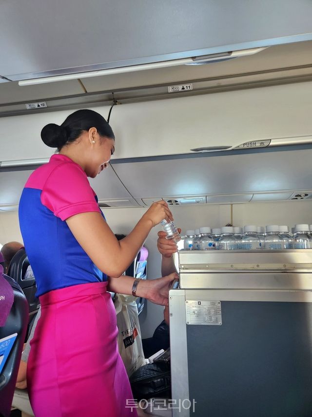 에어스위프트. 마닐라에서 엘니도로 가는 기내에서 물을 나눠주고 있는 승무원​