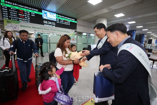 공사 양수배 세종충북지사장(가운데)이 필리핀 마닐라에서 입국하는 관광객에서 꽃다발을 전달하고 있다
