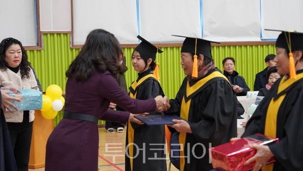지난 9일 손향미 군서초등학교 교장이 박향님(76) 씨에게 졸업장을 수여하고 있는 모습. /사진-박성환 기자