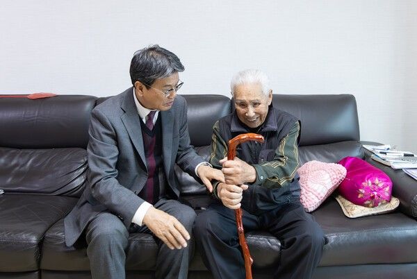 ▲100세를 맞은 화성면 농암리 어르신께 장수지팡이(청려장)를 전달하며 축하 인사를 나누고 있는 김돈곤(왼쪽) 청양군수 모습. /사진-청양군