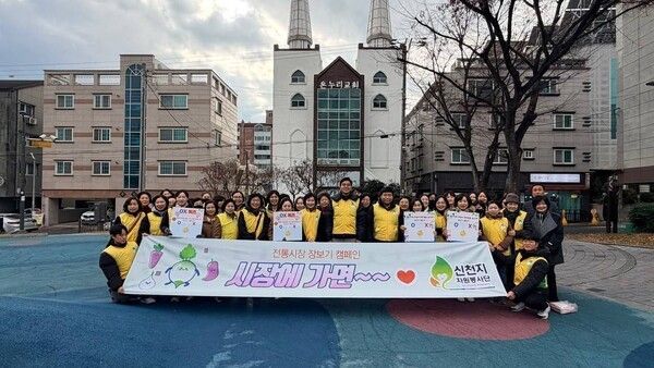 신천지자원봉사단 거제지부가 지난 11일 연말을 맞아 시장 활성화를 위한 장보기 캠페인을 펼친 가운데 관계자들이 기념촬영을 하고 있다/사진제공=신천지자원봉사단 거제지부.
