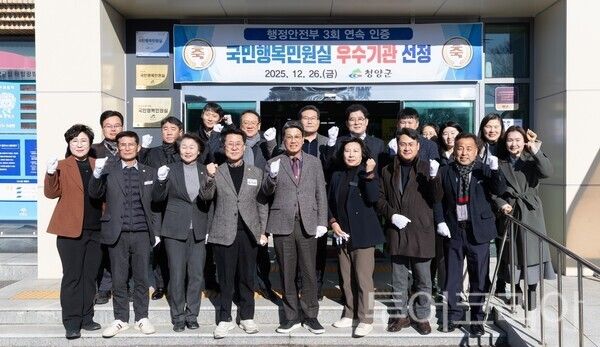 ▲김돈곤(가운데) 청양군수와 김기준 군의회 의장을 비롯한 공무원 20여명이 참석한 가운데 26일 열린 ‘국민행복민원실’ 현판 제막식 기념촬영 모습. /사진-청양군