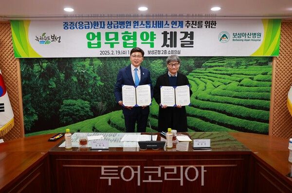 김철우 보성군수(좌)와 최병진 보성아산 병원장(우)이 서명한 협약서를 들고 사진촬영을 하고 있다. /사진-보성군