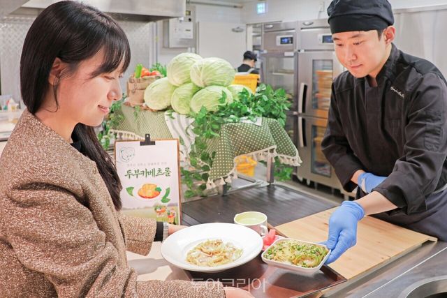 현대그린푸드 직원이 구내식당에서 제주 저탄소 양배추를 활용한 메뉴를 고객에게 제공하고 있는 모습.