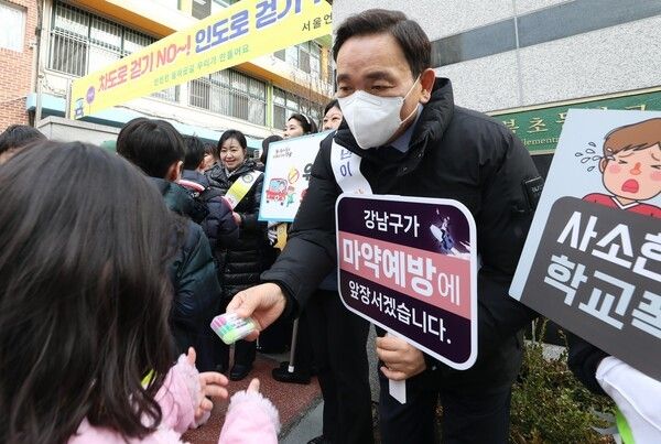 언북초등학교 앞에서 아동·청소년 캠페인 현장에서 학생에게 학용품을 건네고 있는 조성명 강남구청장 (사진제공=강남구청)