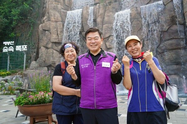 이필형 (가운데)동대문구청장 민선8기 공약에 따라 조성된 배봉산 숲속 폭포 앞에서 구민들과 기념촬영 모습(사진제공=동대문구청)
