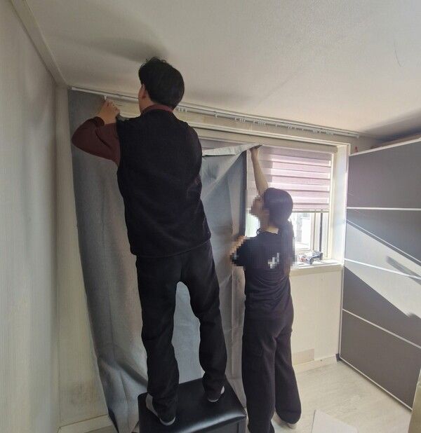 보호관찰 대상자 자녀 학업 환경을 위해 커튼을 달아주고 있다(사진제공=도봉구청)