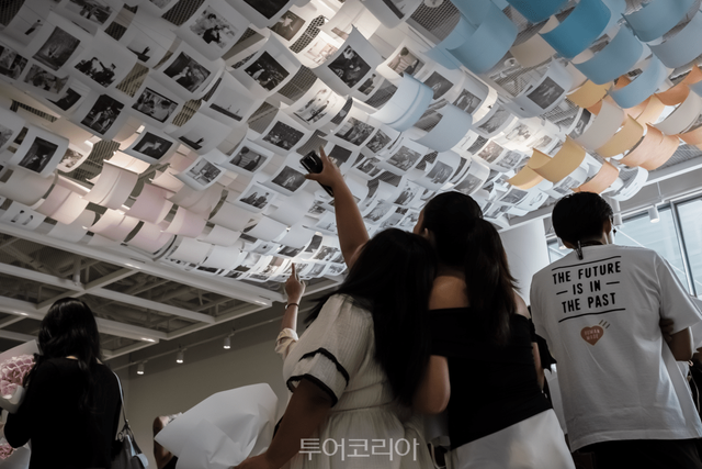 드라마 스틸컷을 활용한 행잉 전시를 관람하는 관람객들